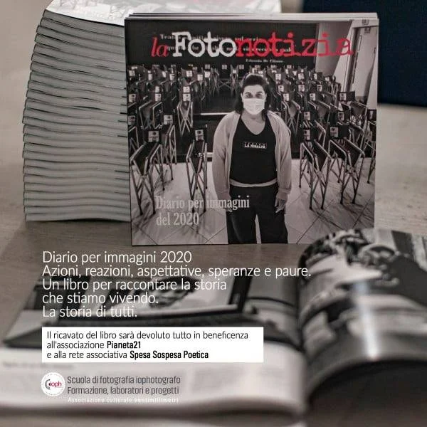 Copertina in bianco e nero del libro fotografico "Diario per immagini 2020", appoggiata su una pila di altre copie del libro.