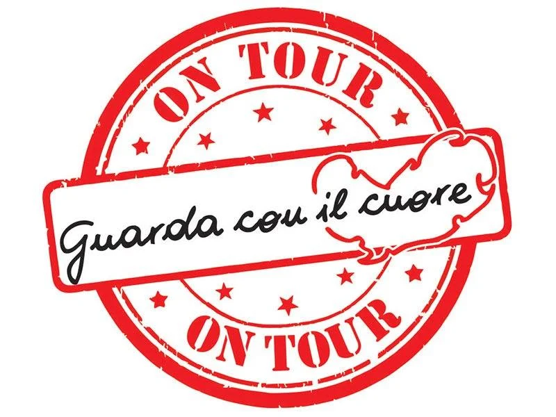 Logo dell'iniziativa "Guarda con il cuore on tour": un timbro rosso a forma di cuore su sfondo bianco.